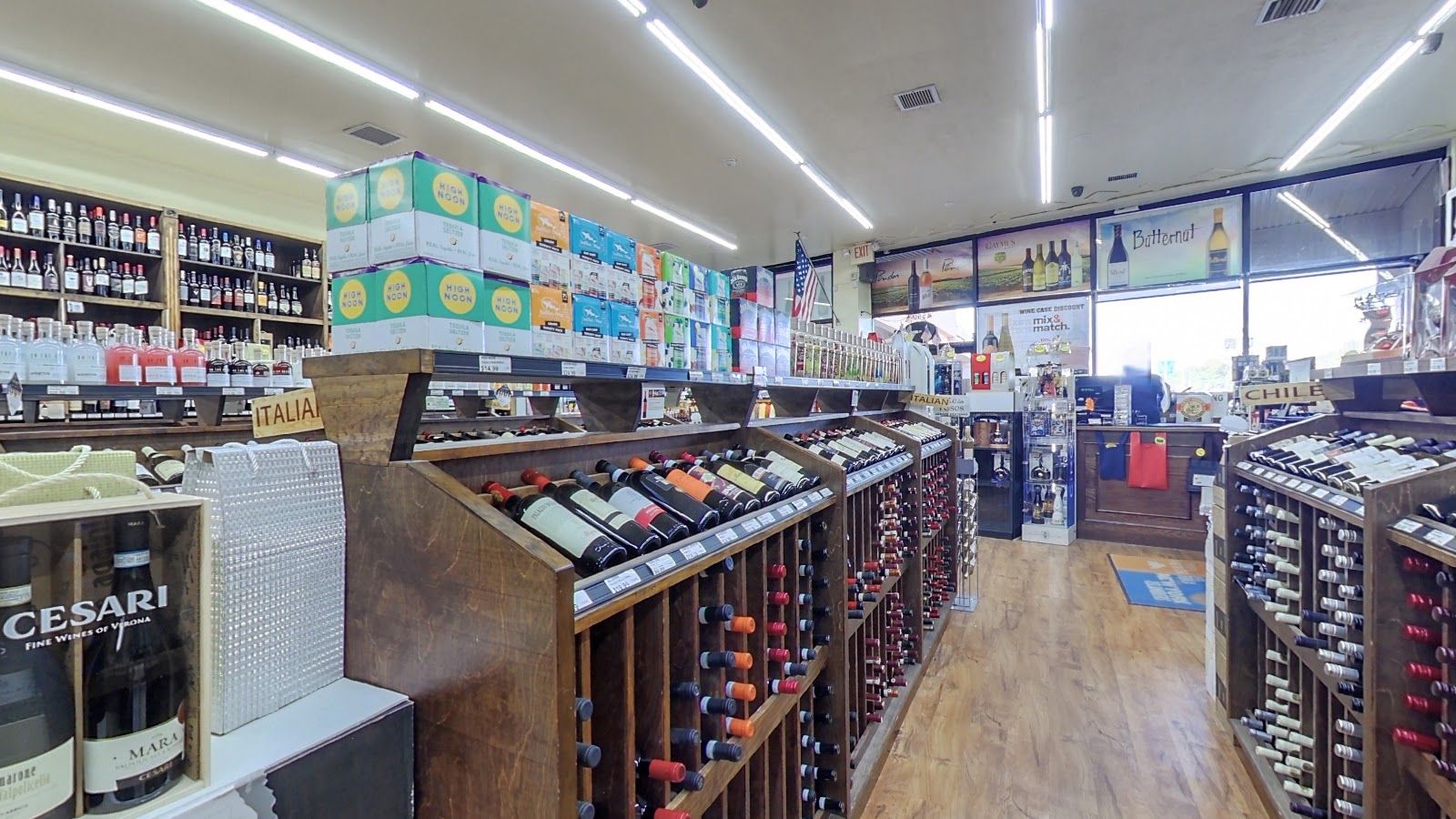 Aisles of wooden wine racks under bright lights at Lake Success Wine & Liquors